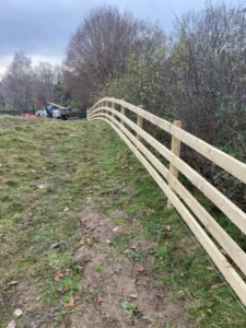 Wooden fencing over a hill in a horse field